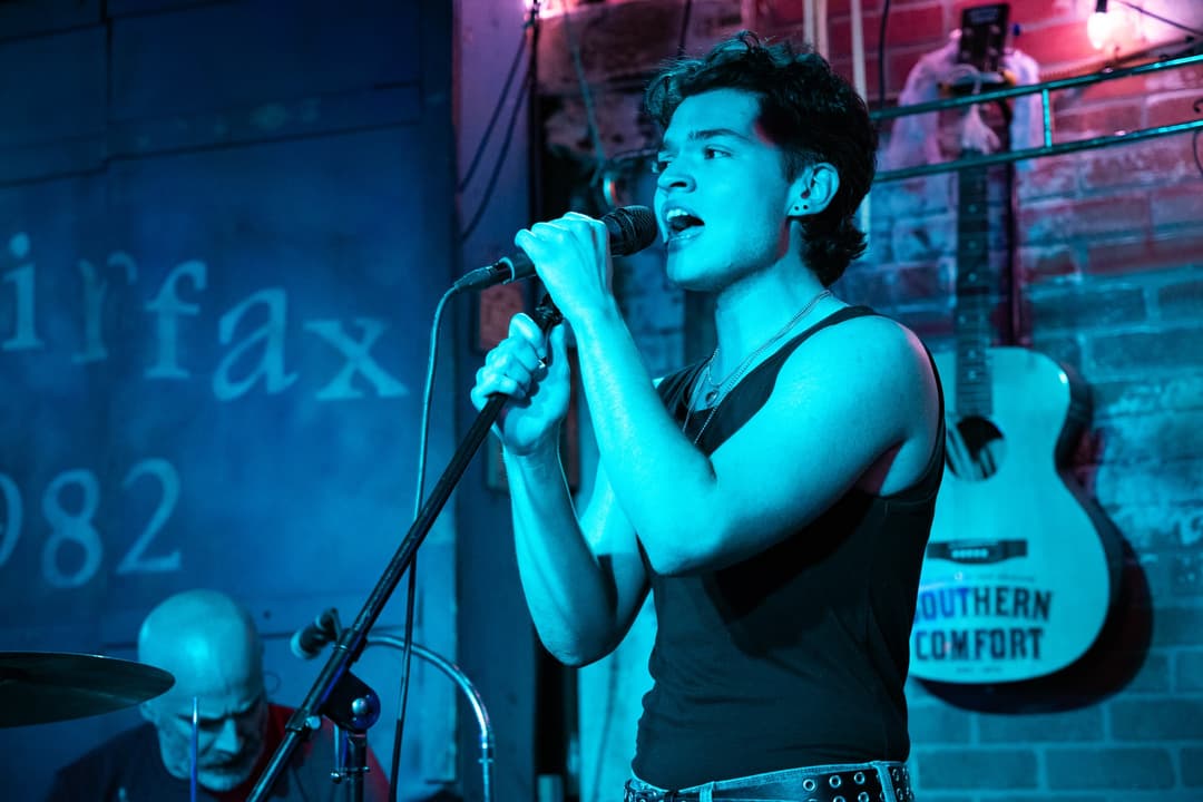Picture of a person singing in a blue light.